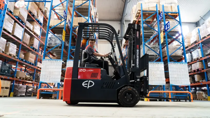 Xe nâng điện TVL181 di chuyển trong kho giữa các kệ cao